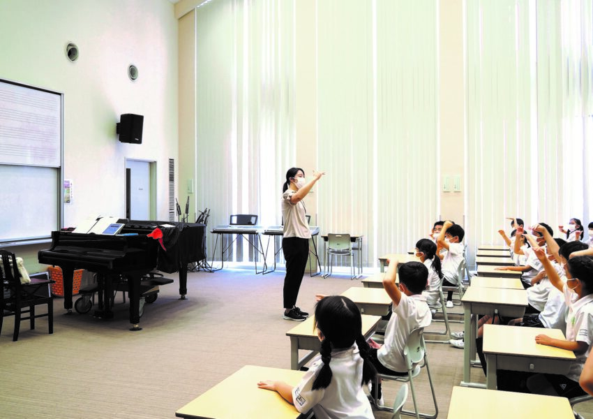 小学校2年生の音楽の授業の様子。手を使って音の高低を学んでいます。